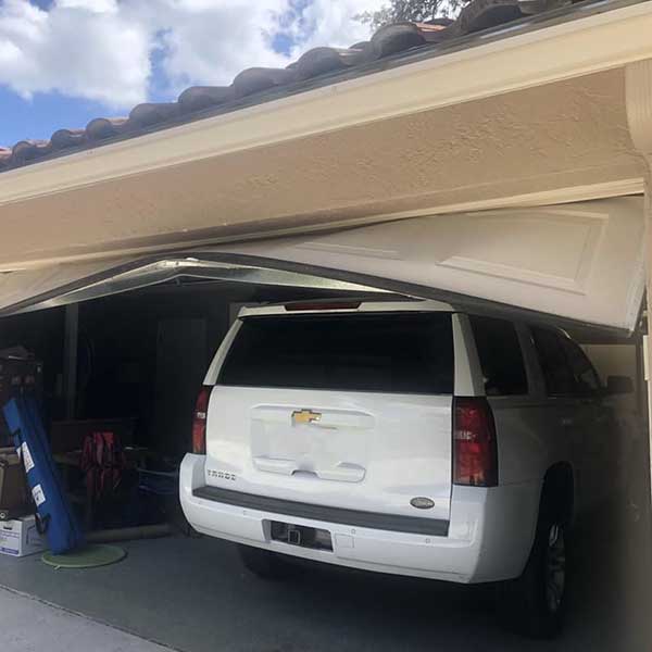 garage door with big dent from car