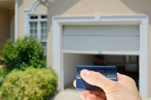 Hand using a remote control to open the automatic garage door in Seminole County, FL