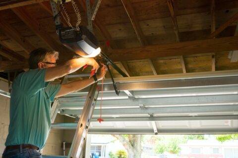 Technician repairing an automatic garage door opener in Seminole County, FL
