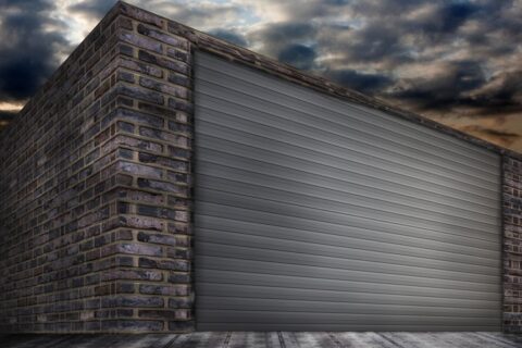 Dark brick building with a grey roller shutter door in Orlando & Central FL