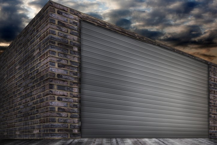 Dark brick building with a grey roller shutter door in Orlando & Central FL