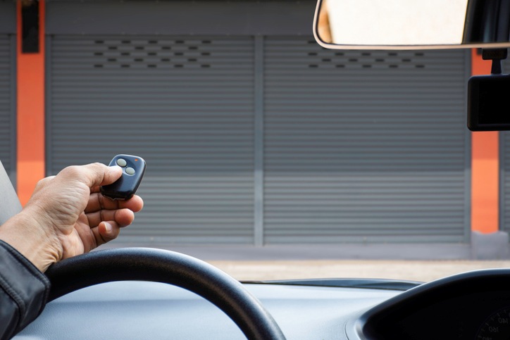 A Person opening a garage door with a remote from inside a car in Orlando & Central FL